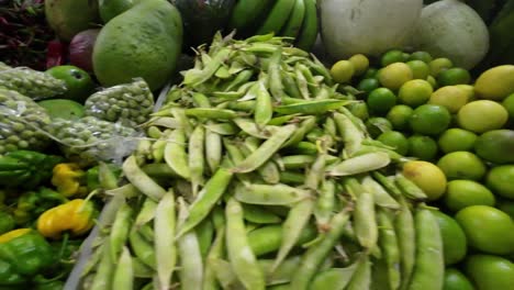 side pan across limes, mangoes, and hot peppers on a colorful market stall in caracas, venezuela.