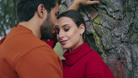 Tender-couple-posing-forest-tree-vertical-closeup.-Young-pair-romantic-weekend