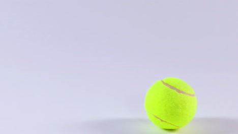 a tennis ball moves across a plain white background, showcasing its vibrant color and simple motion.