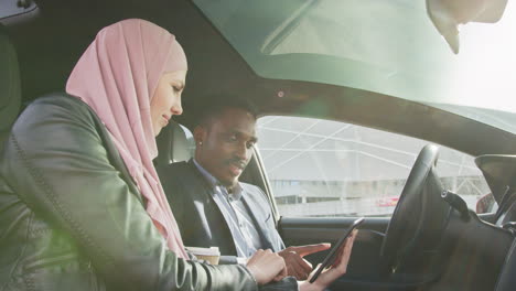 african american businessman in suit and muslim woman in hijab using modern smartphone for remote