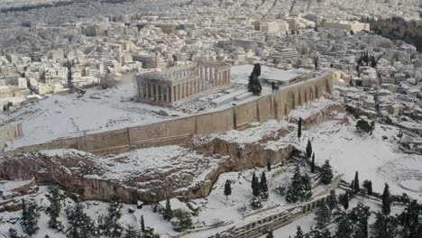 aerial drone view overlooking the snow covered parthenon, unique winter day in athens, greece