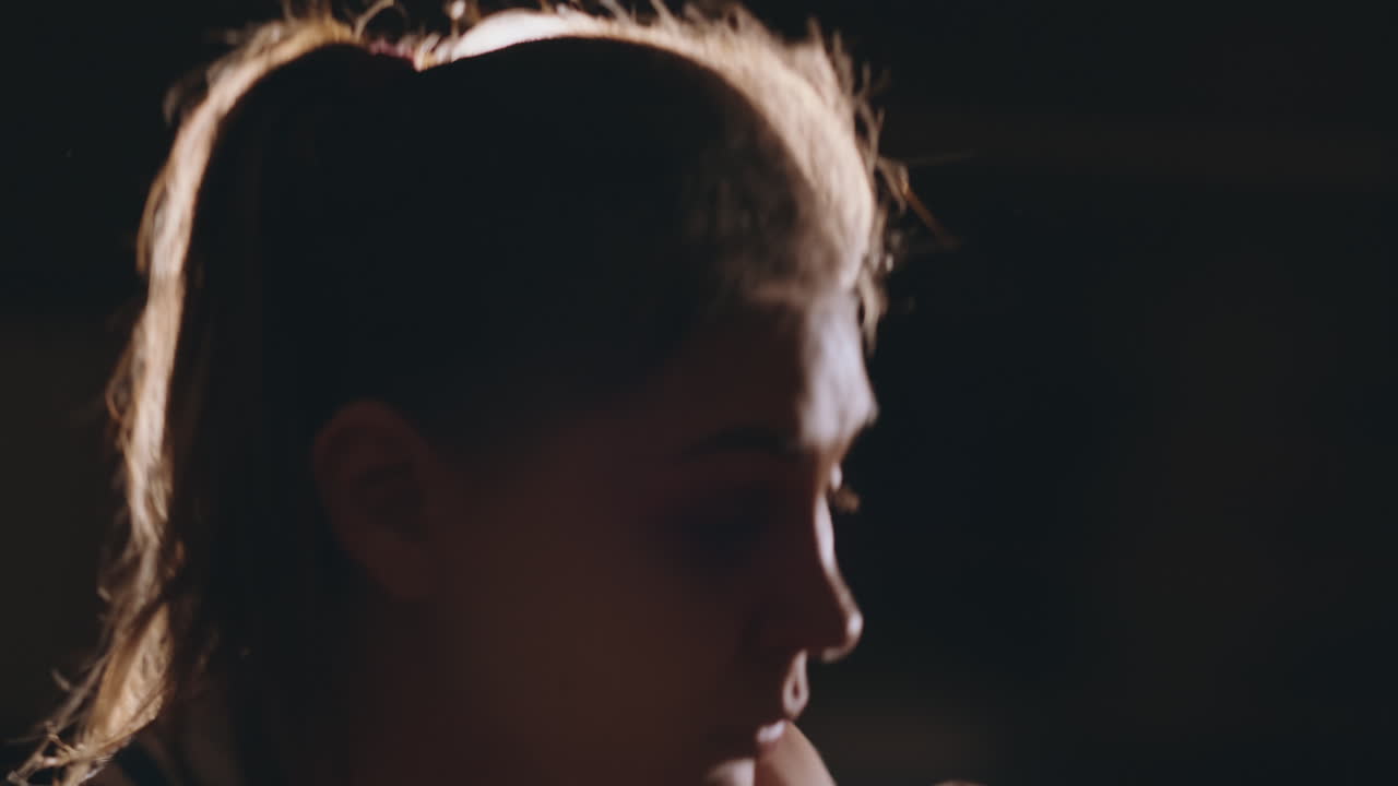 Una pugilessa forte e atletica si allena nella boxe su sfondo nero. Concetto di sport pugilato con spazio per il testo.
