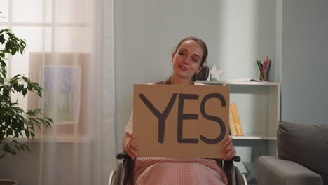 positive disabled woman smiles holding poster with word yes