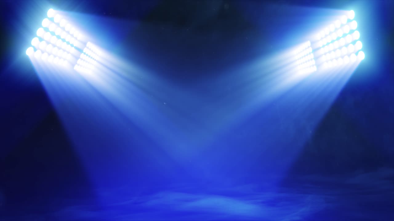 Animated sports graphic background plate, with bright banks of floodlights shining dramatic volumetric light over a misty, atmospheric scene, in deep blue color palette