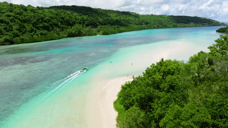 boat cruising in the turquoise clear water in moso island, vanuatu