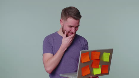 Exhausted-man-freelancer-with-pasted-sticker-notes-using-laptop-computer,-concentration-problem