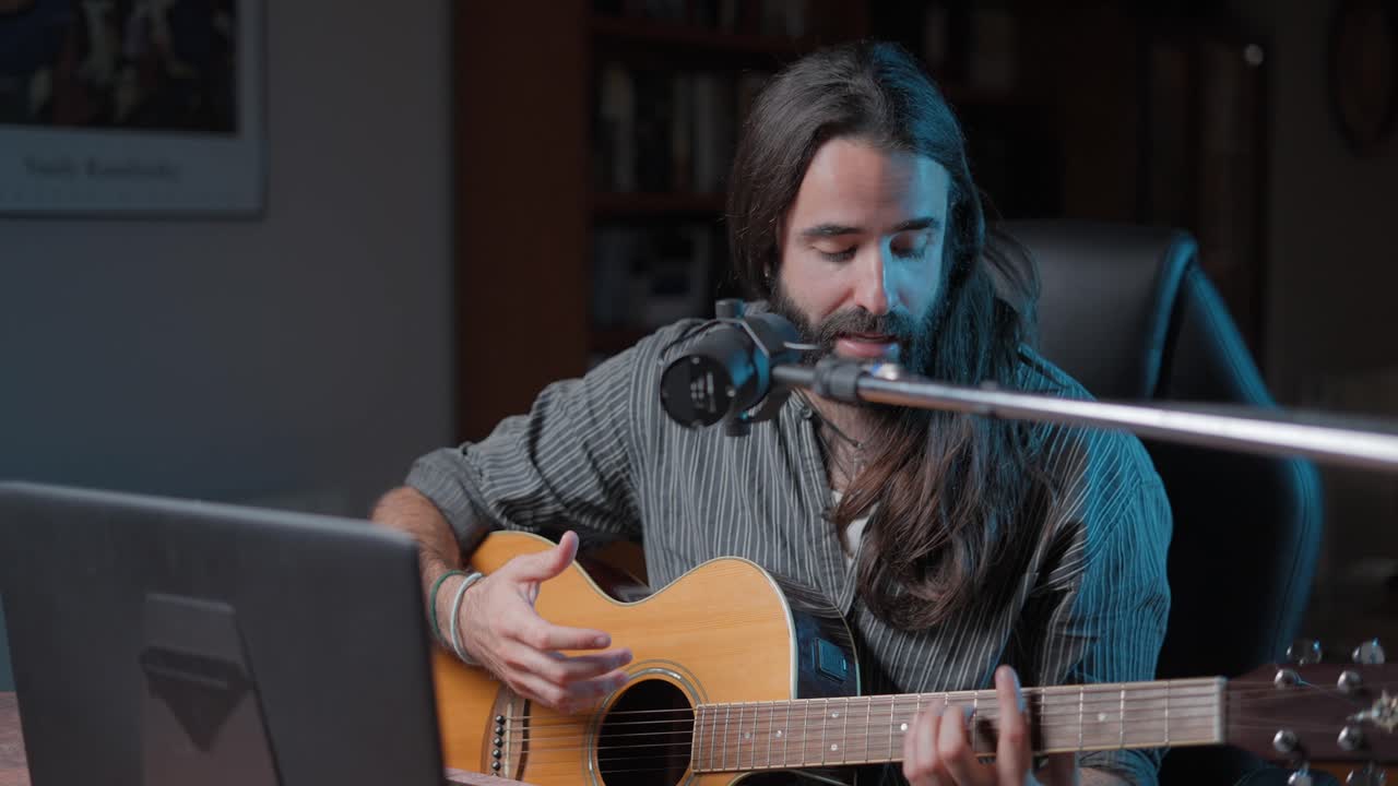 Man Playing Acoustic Guitar and Singing in Home Studio