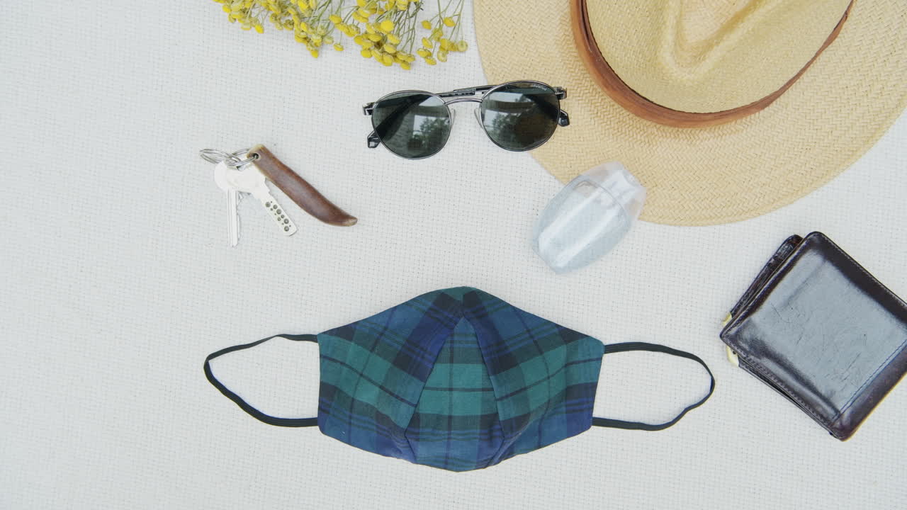 Flat lay of face mask, wallet, keys and other travel accessories for Covid-19