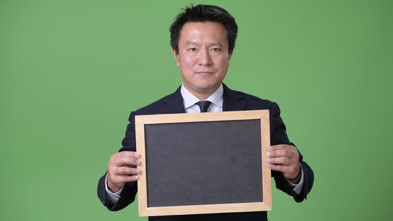 녹색 배경에 성숙한 일본 사업가