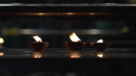 burning diyas oil lamp inside a hindu temple.