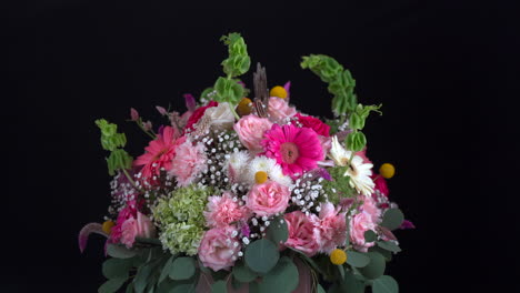 Floral-arrangement-daisy-carnation-roses-spinning-in-black-background-bouquet