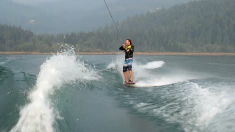 Vorderansicht-Eines-Kaukasischen-Jungen-Mannes,-Der-Tricks-Auf-Dem-Wakeboard-Im-Stadtfluss-Macht,-4k