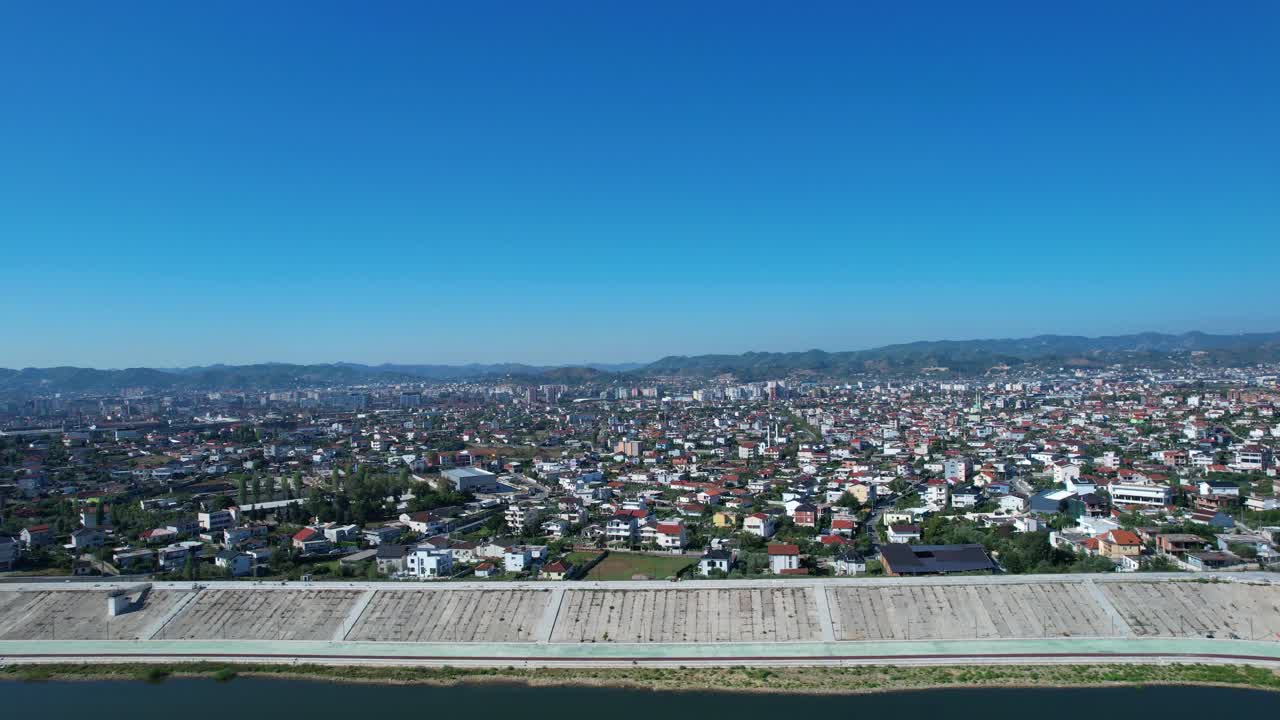 Reservoir dam over Tirana suburban neighborhoods with private houses, urban development and population density
