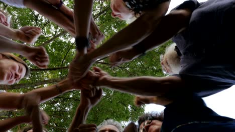 un grupo de generaciones mixtas de personas golpeando los puños para celebrar