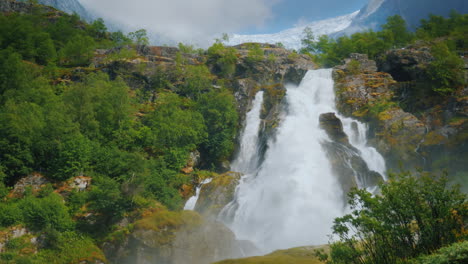 hermosa cascada de las aguas del glaciar en el fondo la montaña con hielo en la parte superior es