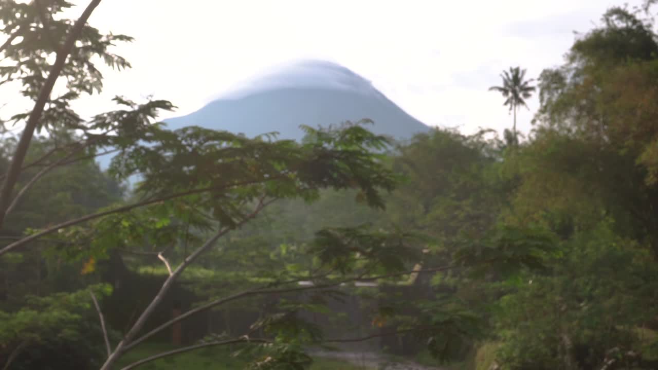 Merapi Volcano in Yogyakarta, Indonesia cone shaped peak in lenticular cloud.
