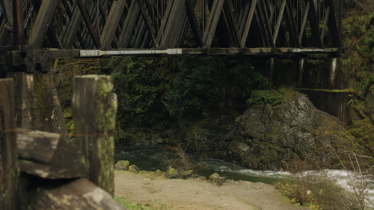 A ghostly mist drapes the old train bridge, adding an air of mystique to its weathered frame. Evoking a sense of nostalgia and reverie.