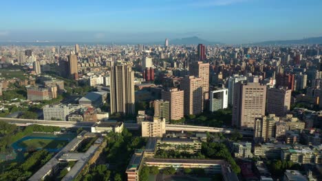 Aerial-flyover-capital-city-of-Taipei-in-Taiwan-during-sunset-and-blue-sky