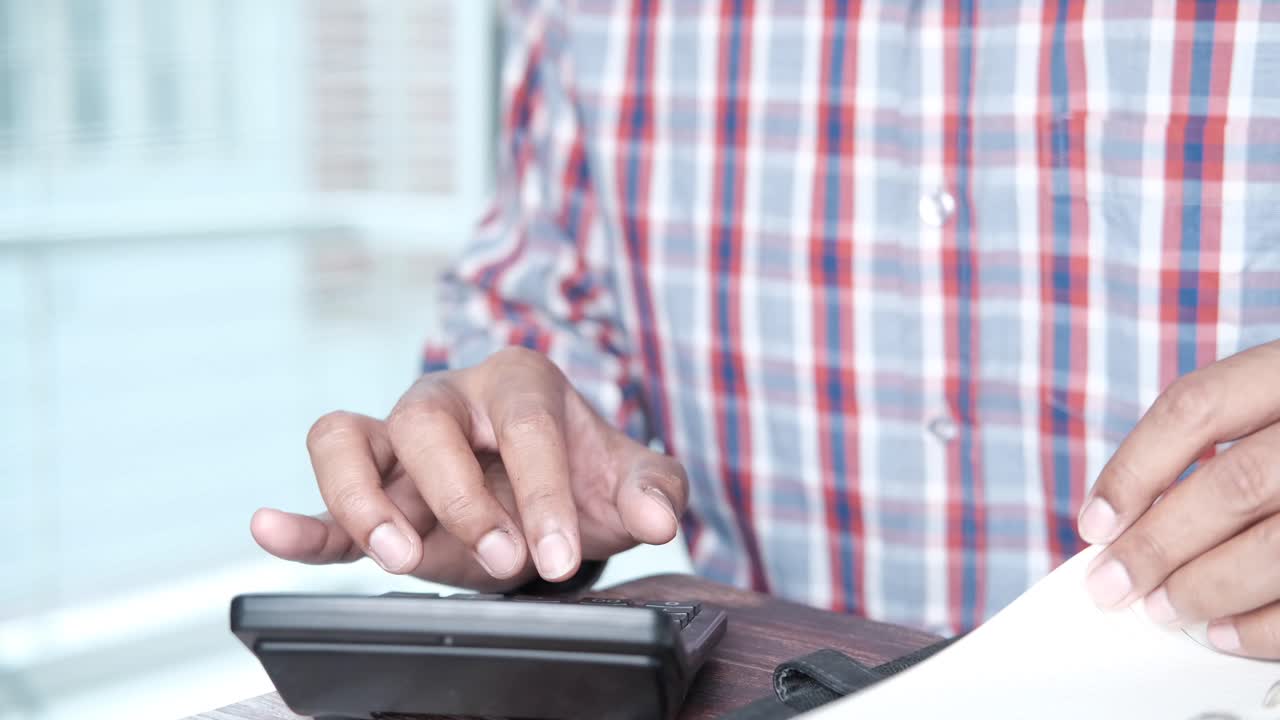 persona que utiliza una calculadora y un cuaderno