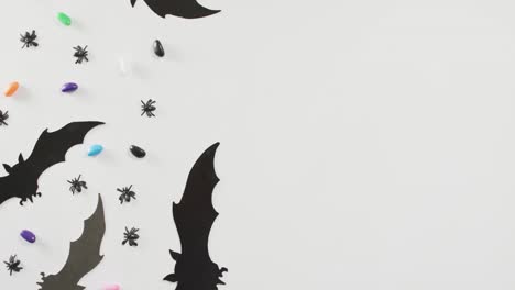 close up of multiple halloween toys and candies with copy space on white background