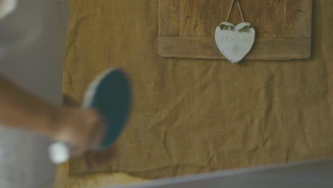 detalle de una niña golpeando la pelota con su paleta de ping pong azul, un momento de juego y formación de equipos corporativos en una taberna cubierta en una tarde de verano