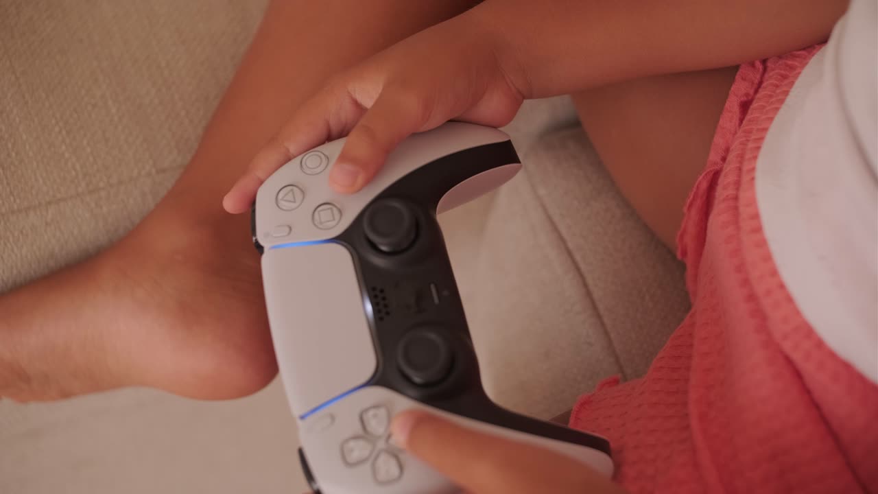 Child playing video games with a Playstation controller