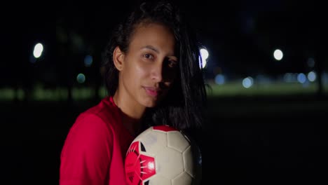 Una-Joven-En-Bikini-Sostiene-Una-Pelota-De-Fútbol-Mientras-Cae-La-Noche.