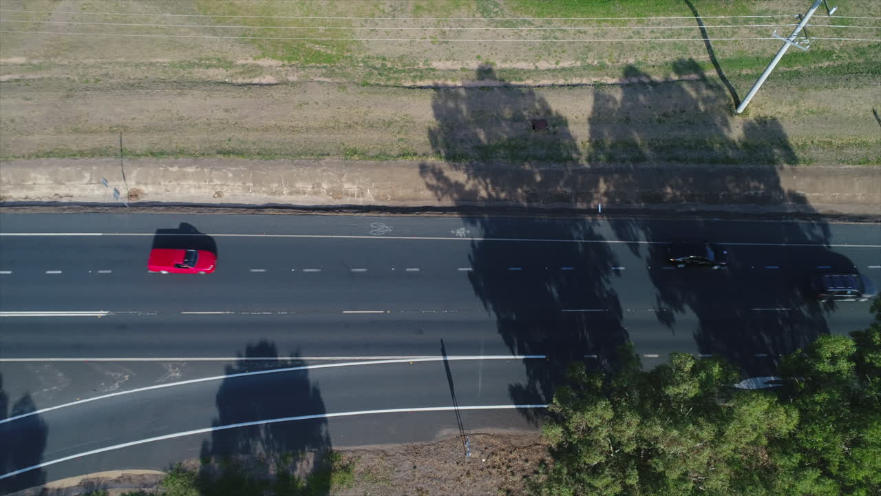 Aerial topdown of cars merging from on ramp in a rural city during the morning commute in Australia