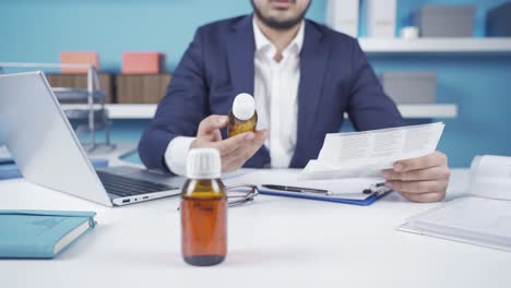 businessman reading the prospectus of the health drugs he will use at his desk in the office.