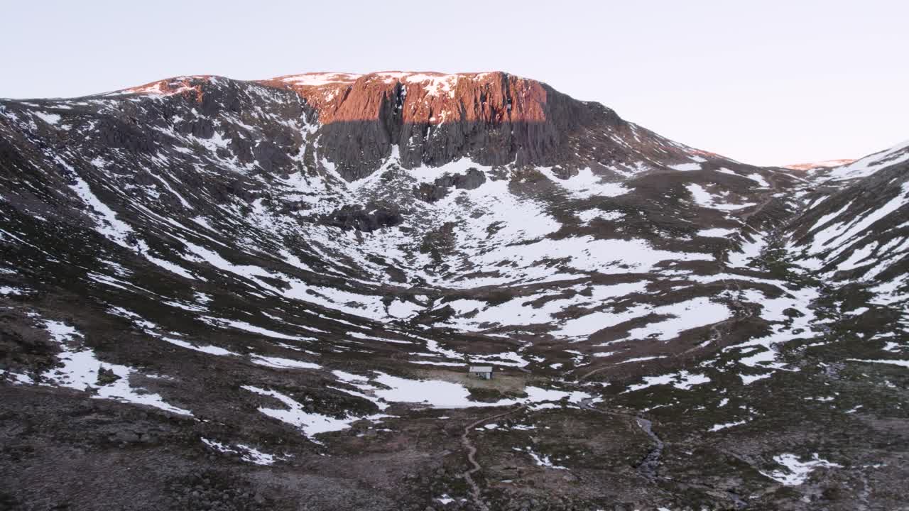 허치슨 기념관과 겨울의 눈 속에서 극적인 산, 절벽, 야생 황무지 풍경과 함께 일출을 보여주는 공중 드론 영상