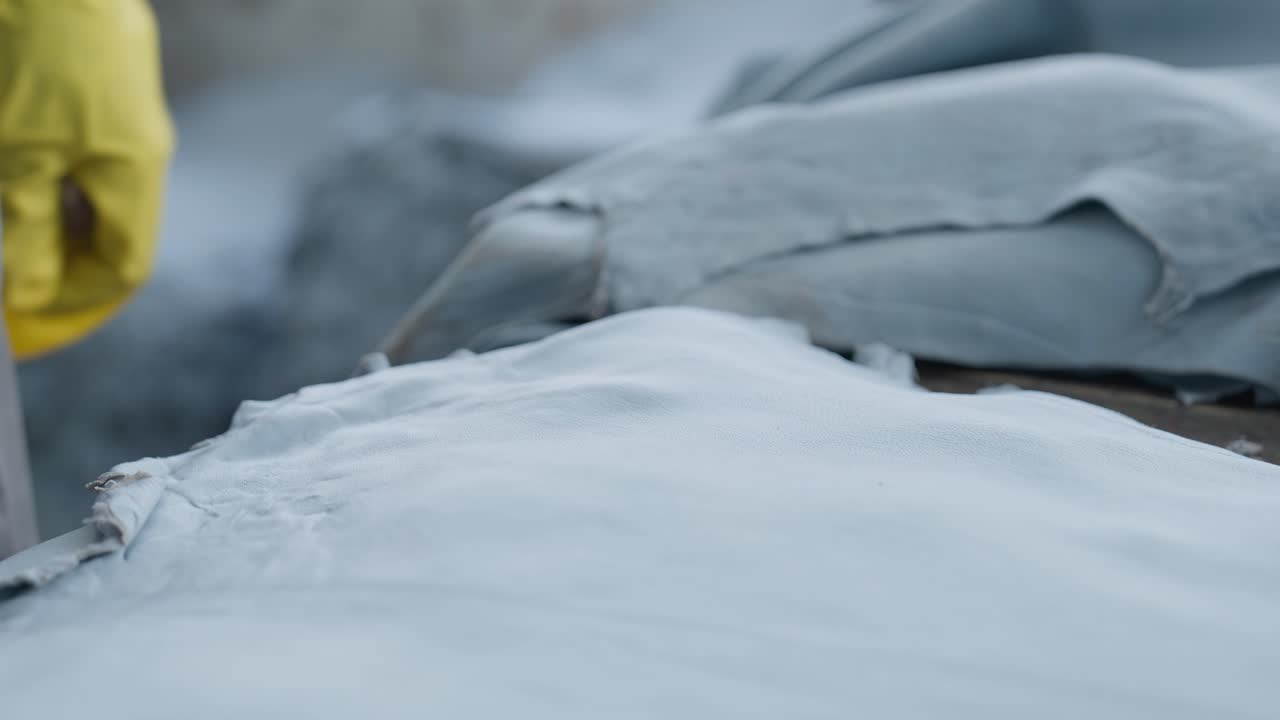 trabajador midiendo y marcando pieles con un lápiz de cera roja en una fábrica de textiles, disparo de cerca