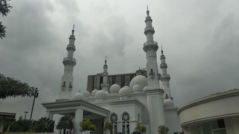 Static-shot-of-At-Thohir-Mosque-with-darken-sky-in-the-background,-a-magnificent-white-mosque-located-in-the-Podomoro-Golf-View-area,-Tapos,-Depok,-West-Java,-Indonesia