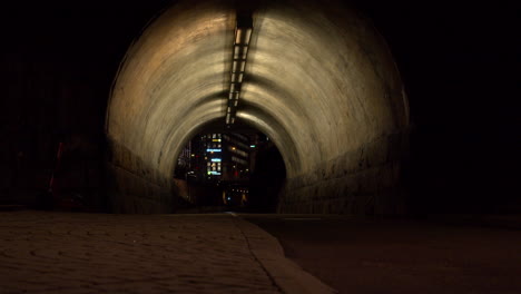 night cycling: biker rides through the illuminated tunel