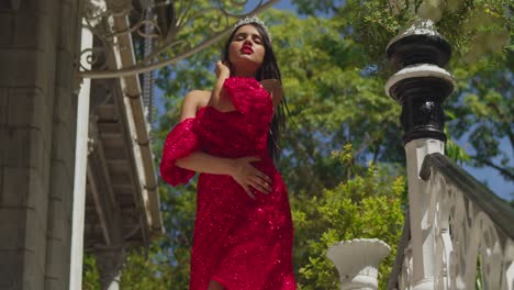 amidst the faded grandeur of a caribbean castle, a young woman's red gown brings a sense of vibrancy to the ancient halls