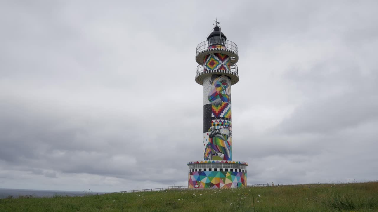 Colorful lighthouse with artistic mural in Faro de Ajo, Cantabria, Spain