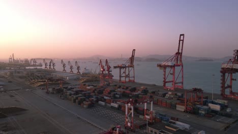 aerial video of cranes and containers at the wharf at dusk