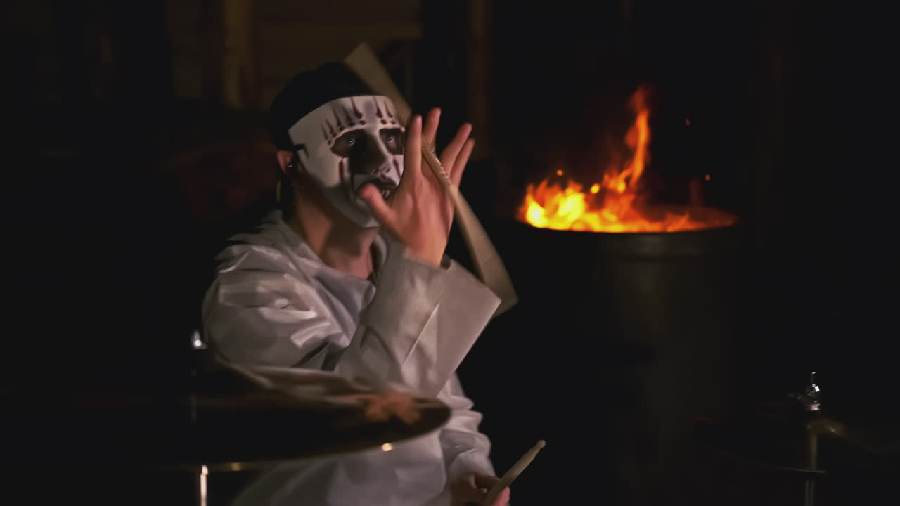 baterista con máscara en un entorno oscuro