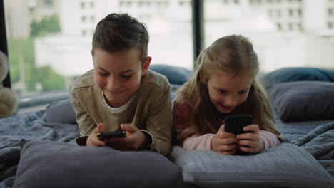 Siblings-playing-mobile-games-indoors.-Friends-looking-smartphones-screens.