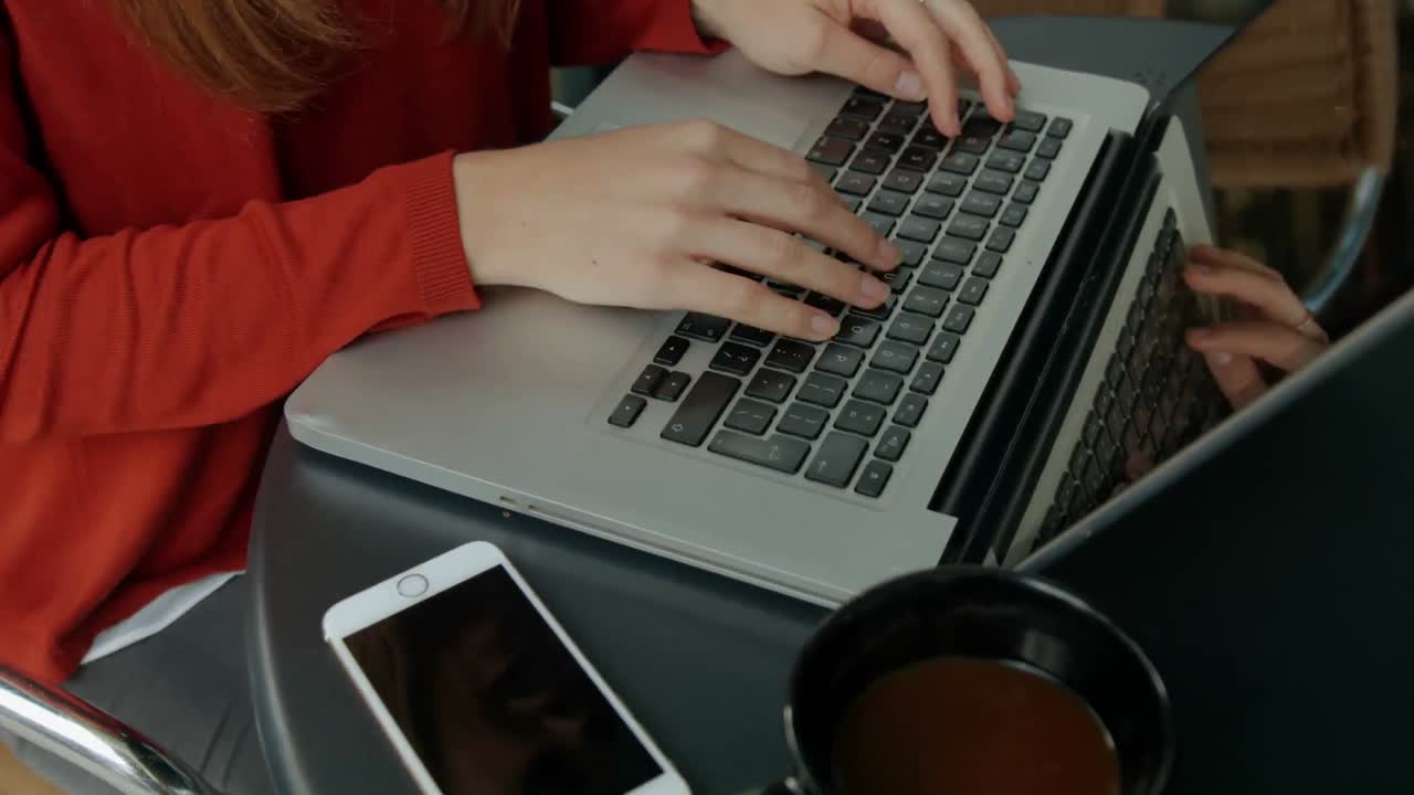 mujer usando una computadora portátil en el café