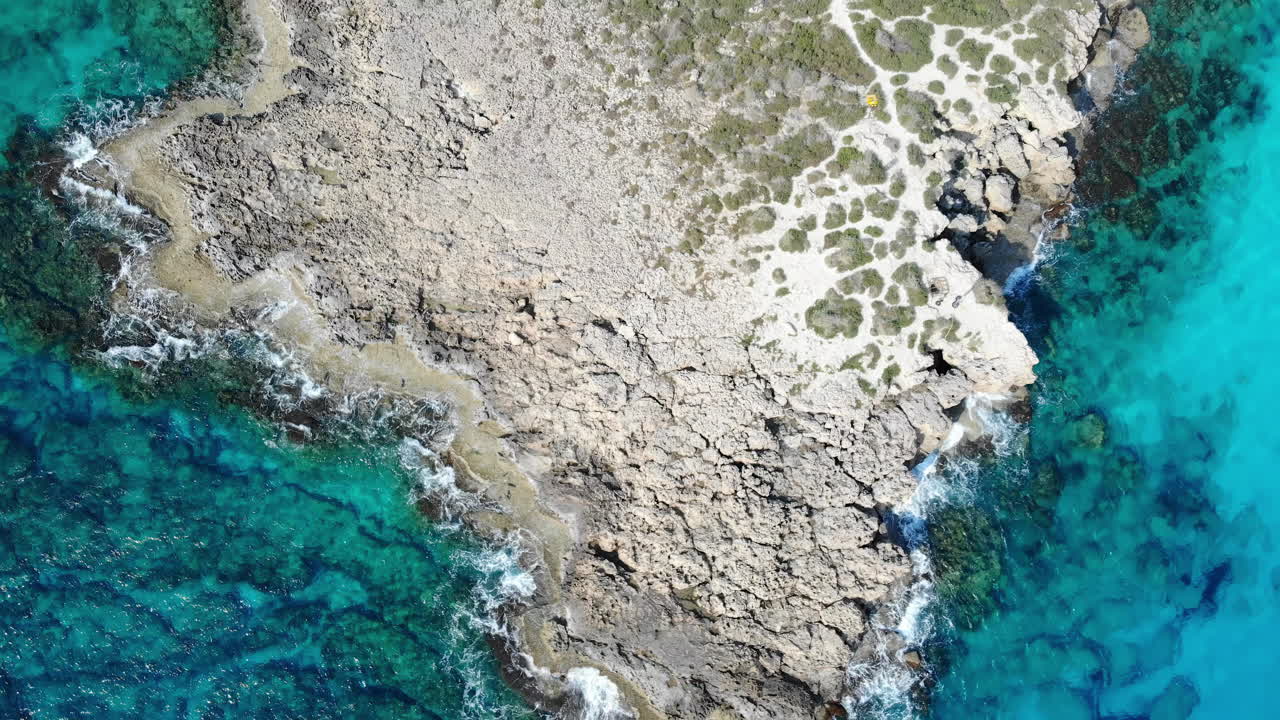 Aerial drone view of waves hitting the rocks on the shore in Limassol, Cyprus