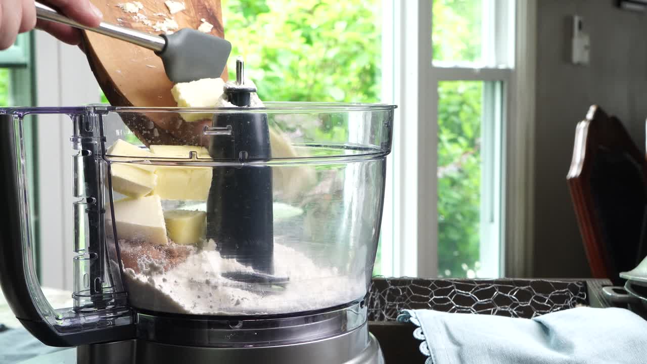Using a food process or blender to make a dessert crust. Close up of mixing baking ingredients to make a dessert with a pie crust. Making brownies with a food processor for dessert.