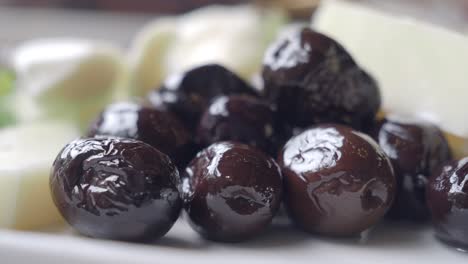 closeup of black olives on a white plate