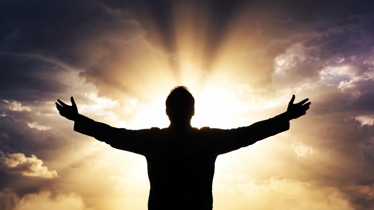 Una persona si erge contro uno sfondo mozzafiato di luce radiosa che squarcia nuvole scure, incarnando un momento di potenziamento, speranza e connessione con l'universo