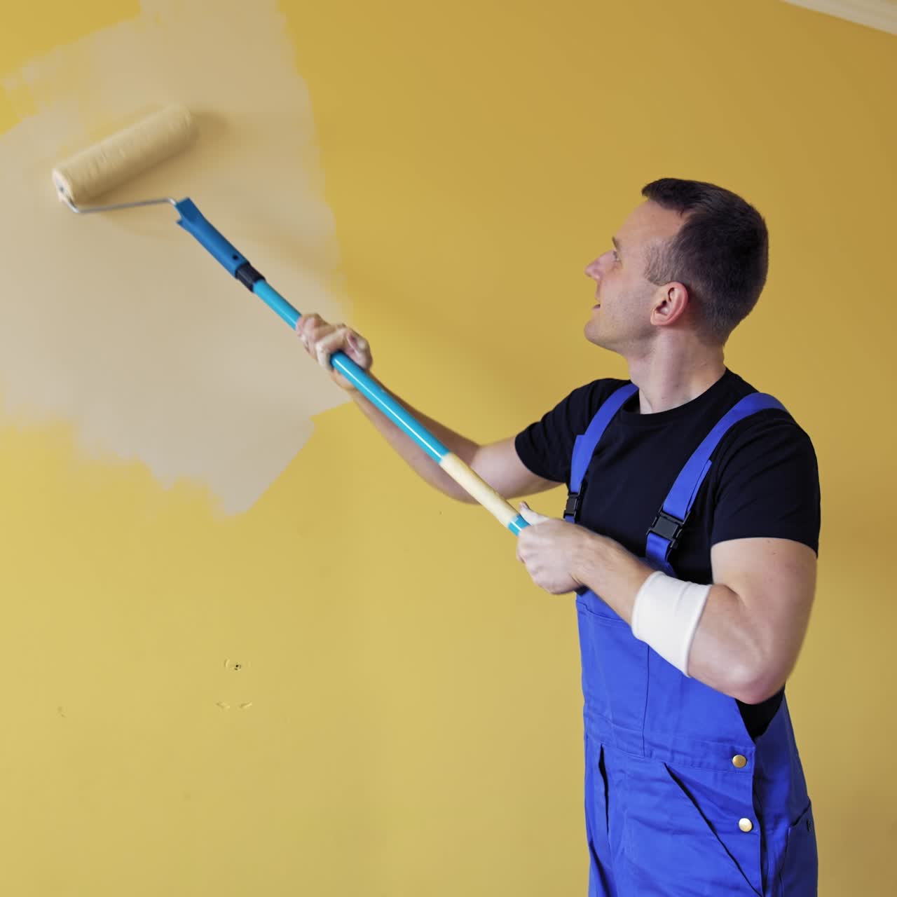 Handsome male painter doing room improvement. Attractive man improve house interior