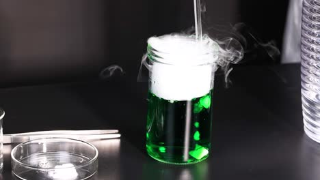 green liquid reacts, producing smoke and vapor