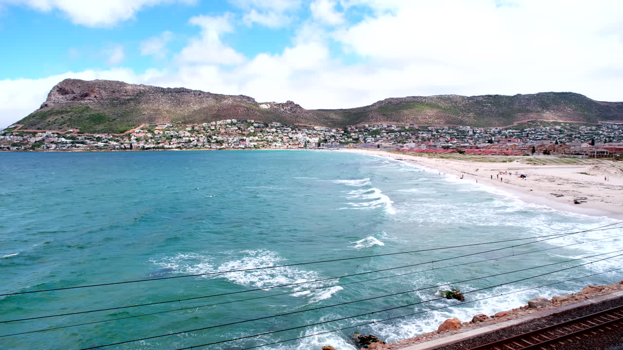 Top view over Fish Hoek white sand beach and crashing waves