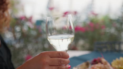 woman at the beach resort smelling the scent of the white italian wine