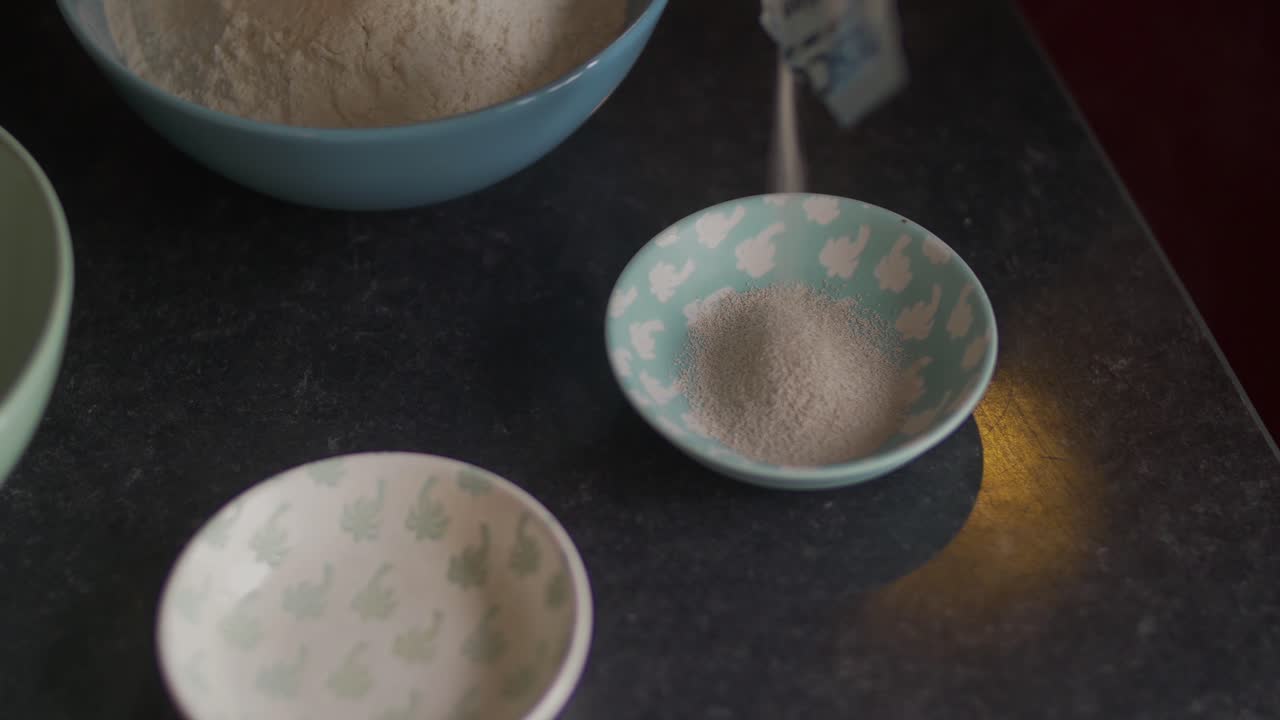 피자를 만들기 전에 작은 접시에 효모를 붓는 샷을 닫습니다.