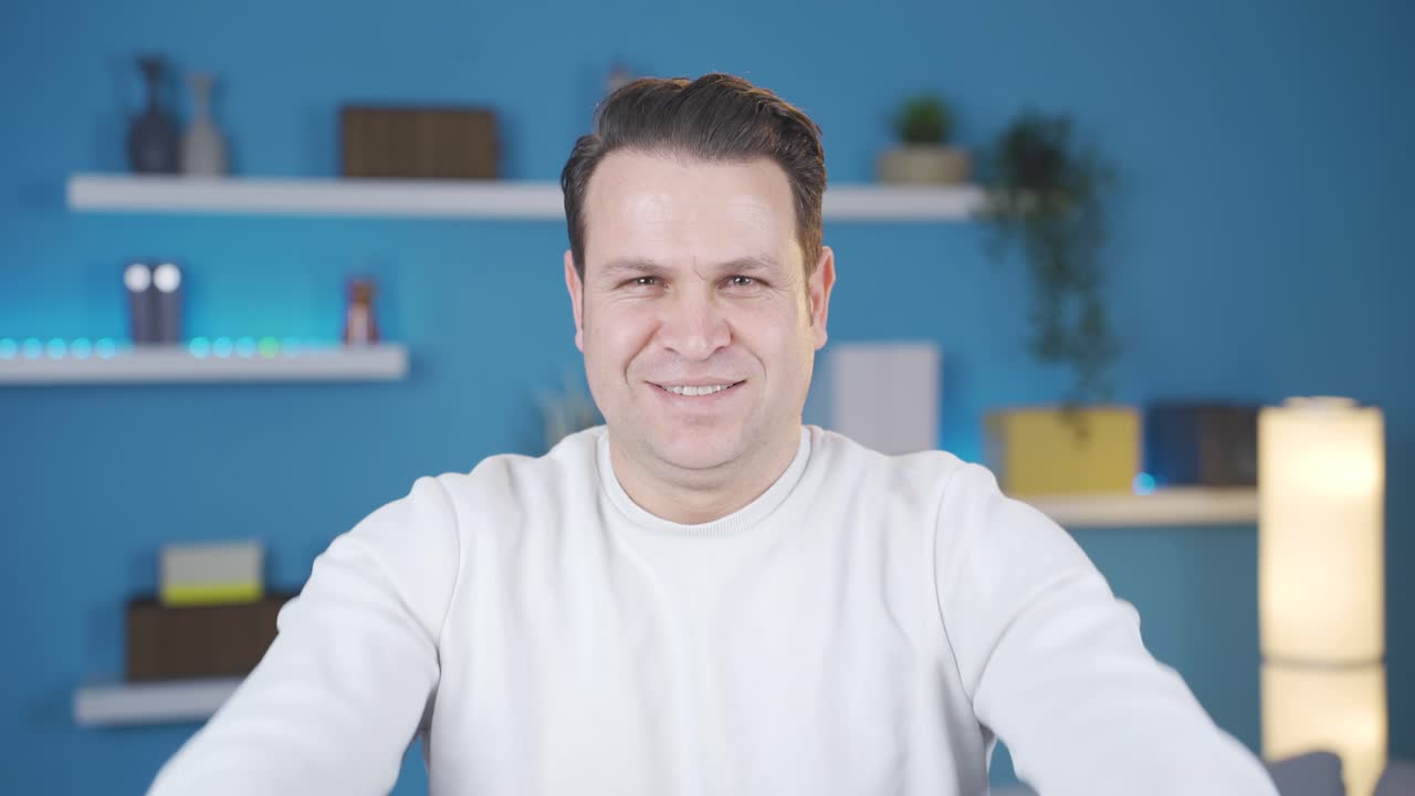 즐겁고 행복한 남자가 집에서 심장 기호를 만들고 있습니다.