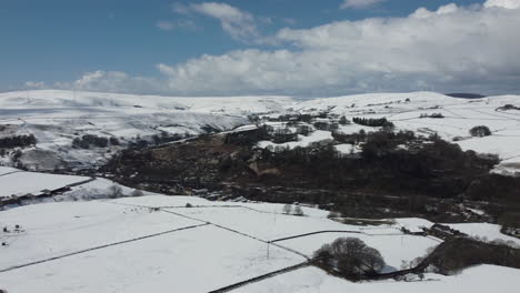 Winter-landscape-panning-shot-with-farms-and-snow-covered-open-field